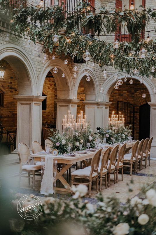wedding receptino with candles, outdoor setting in a castle-like courtyard